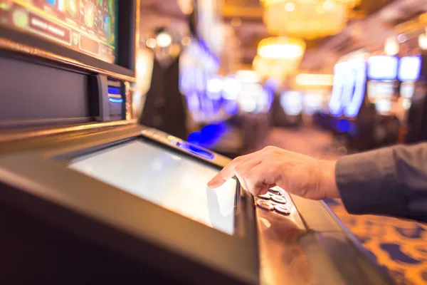 Un homme concentré sur son ordinateur portable avec des statistiques en direct en arrière-plan, mettant en avant les fonctions sport et casino de l'application mobile BOOMERANG.