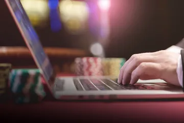 Un croupier professionnel en smoking accueille les joueurs à une table de roulette, symbolisant l'ambiance authentique du casino en direct sur BOOMERANG.