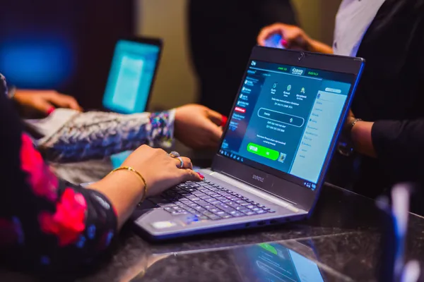 Un croupier sûr de lui entouré de jetons invite les joueurs à accéder à leur compte BOOMERANG, reflétant des options de connexion simples et rapides.